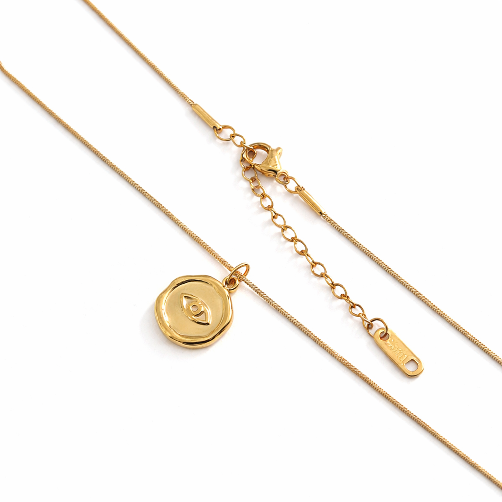 Gold eye pendant necklace on white background