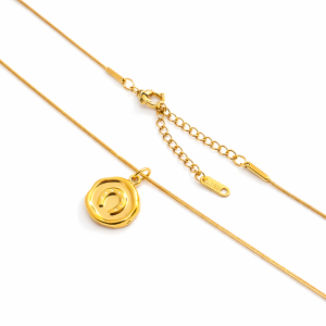 Gold horseshoe pendant necklace on white background